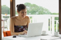 Woman in cafe using laptop - Yukmin