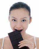 Young woman eating a bar of chocolate - blueduck