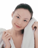 Young woman looking at camera, wiping face with towel - blueduck