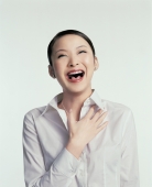 Young woman laughing, hand on chest - blueduck