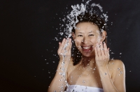 Woman splashing her face with water, smiling - Yukmin