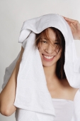Woman drying her hair with towel, smiling at camera - Yukmin