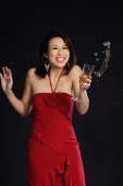 Woman in red dress, holding wine glass, liquid spilling out of glass - Yukmin