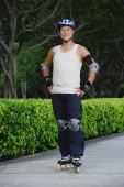 Mature adult with roller blades, standing with hands on hips - Yukmin