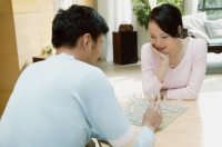 Couple in living room playing chess - blueduck
