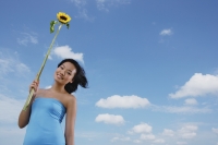 Woman holding sunflower stalk - Yukmin