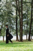 Young woman in traditional Chinese costume, walking amongst trees - Yukmin