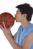 Young man kissing basketball - blueduck