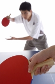 Two men playing table tennis, focus on the foreground - blueduck