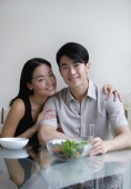 Couple sitting at dining table, looking at camera - Yukmin