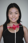 Young woman holding flower, head shot - Yukmin