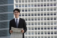 Businessman with newspaper, building behind him - Yukmin