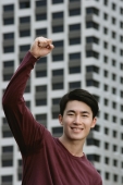 Man smiling at camera, hand raised in a fist - Yukmin