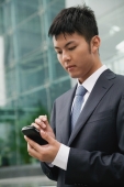 Businessman using PDA, city location - blueduck
