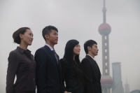 Business people standing in a row, looking away, Oriental Pearl TV Tower in the background - blueduck