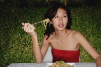 Woman in restaurant eating plate full of pasta - Yukmin
