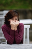 Woman sitting at an outdoor cafe, cover half of face with turtleneck sweater - Yukmin