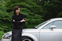 woman leaning on sports car, side of the road, smiling at camera - Yukmin