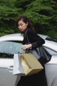 Woman carrying shopping bags and getting into car - Yukmin