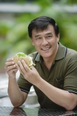 Man sitting outside eating a sandwich - Yukmin