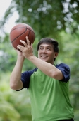 Man playing basketball in park - Yukmin