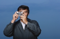 Man taking picture with camera up to eye - Yukmin