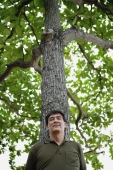 Man standing under tree, relaxing - Yukmin