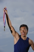Man winning race, holding medal, smiling - Yukmin