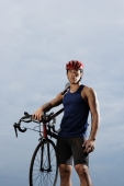 Man holding bike over shoulder, looking at camera, wearing helmet - Yukmin