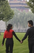 A couple hold hands in front of The Forbidden City, Beijing - Alex Mares-Manton