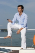 Man with mobile phone on yacht - Yukmin