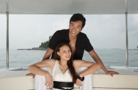 Couple on yacht, smiling at camera - Yukmin