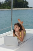 Young woman on yacht, using laptop - Yukmin