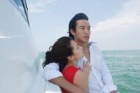 Young couple on yacht with arms around each other - Yukmin