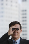 Businessman looking though binoculars - Yukmin