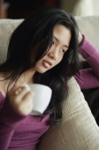 Young woman relaxing with cup of tea - Yukmin