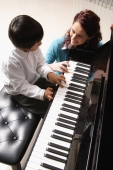 Piano teacher with little boy playing piano - Alex Mares-Manton