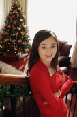 Young woman on the stair at Christmas time smiling at camera - Alex Mares-Manton