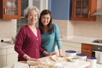 Mother and daughter making dumplings in the kitchen - Alex Mares-Manton