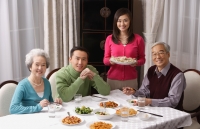 Family at dinner table having traditional food - Alex Mares-Manton
