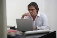 Businessman using laptop at the desk - Yukmin