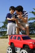 Father and son at the beach with remote controlled toy - Yukmin