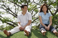 Young couple sitting on ground at the park - Yukmin