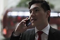 Young man talking on phone on busy street - Alex Mares-Manton