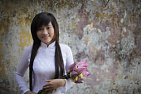 Young woman wearing traditional Vietnamese dress holding lotus flowers - Alex Mares-Manton