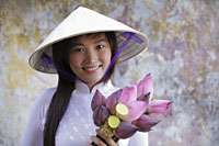 Young woman wearing traditional Vietnamese outfit holding Lotus flowers - Alex Mares-Manton