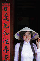 Young woman wearing traditional Vietnamese outfit standing next to a temple door - Alex Mares-Manton