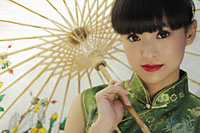 Head shot of young woman in Chinese traditional dress holding an umbrella - Alex Mares-Manton