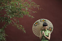 Young woman wearing a traditional Chinese dress holding an umbrella - Alex Mares-Manton