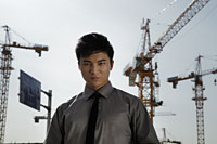 Young man standing in front of cranes - Alex Mares-Manton